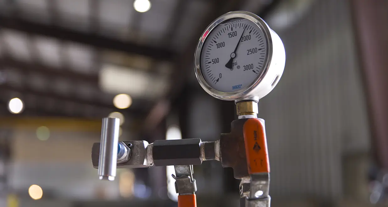 A close up of the pressure gauge on a pipe